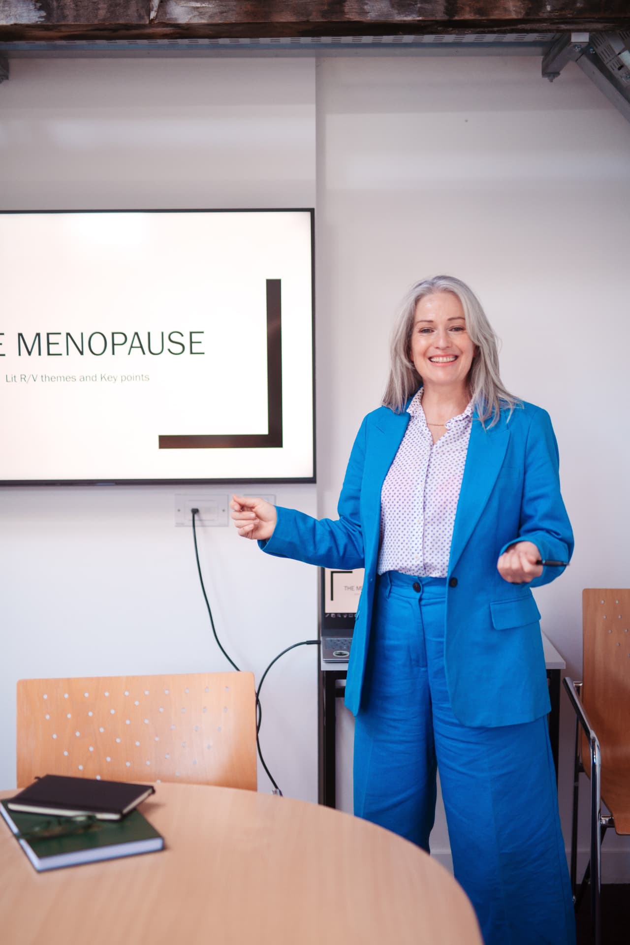 Ruth teaching a menopause education session beside a presentation screen