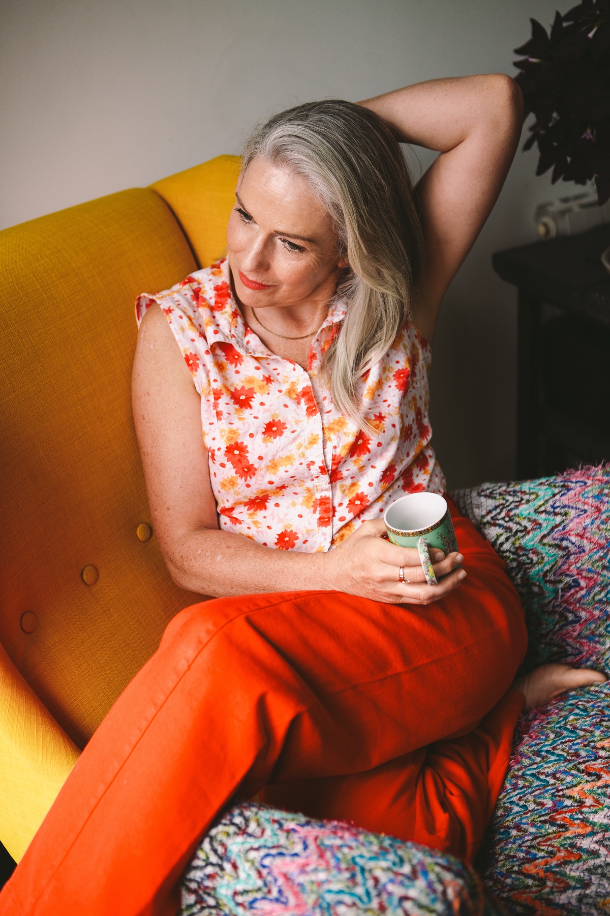 Ruth Molloy, seated and thoughtful, holding a mug