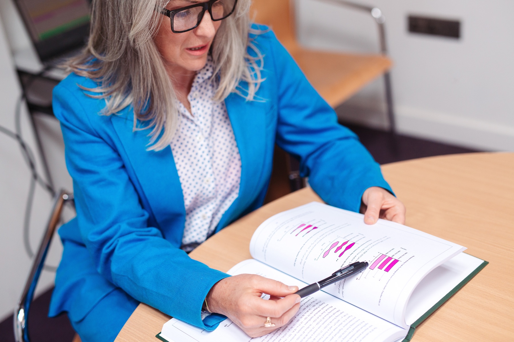 Ruth Molloy reviewing research data, pen in hand, at a desk